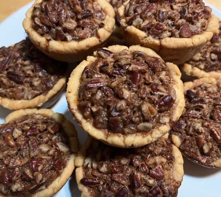 Close up of mini pecan pies on a white plate