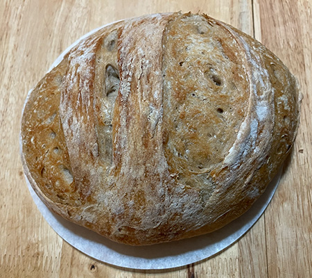 Sourdough boule on parchment on a wooden table